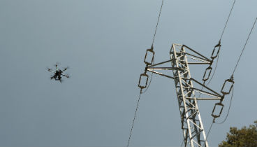 Drones flying over electricity pylons during network maintenance