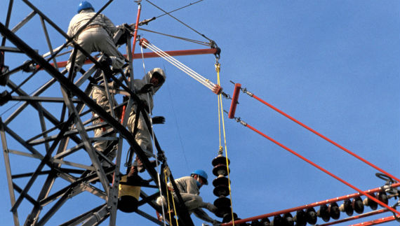 A worker is doing preventive work in a power tower