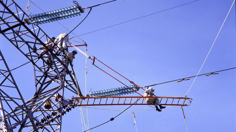 An operator is doing maintenance work on a power tower