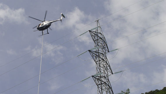 Helicòpter reparant una línia elèctrica