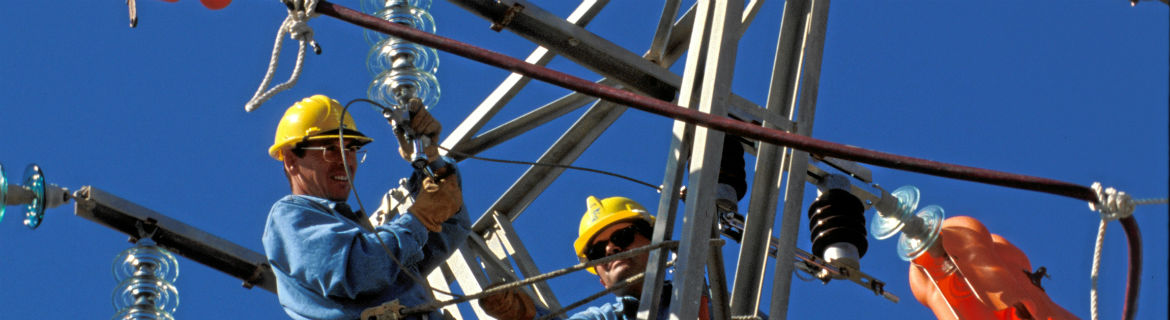 Workers doing repairs and maintenance work on an electric tower