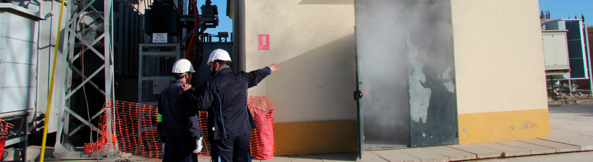 Two operators check the smoke coming out of an electrical transformation centre