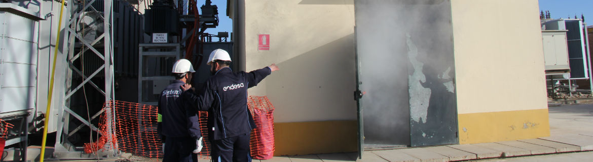Dos operaris revisen el fum que sali d'un centre de transformació elèctrica