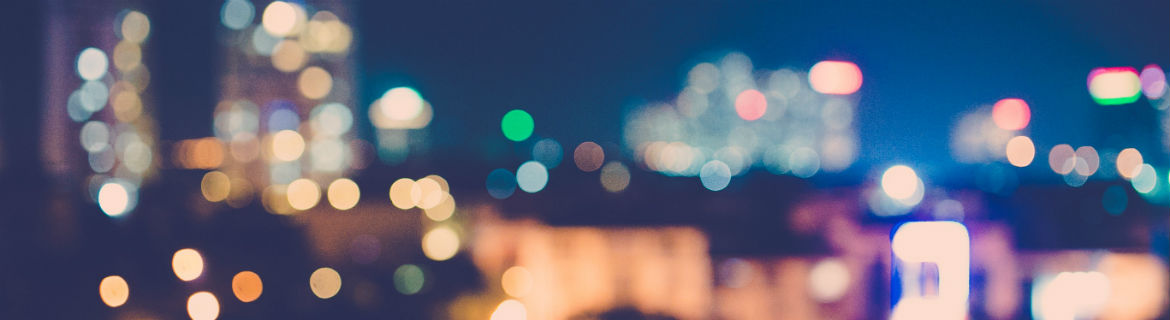 A blurred image of a large city lighted up and connected to the smart grids