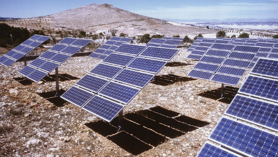 Instal·lació de plaques fotovoltaiques enfront d'una muntanya